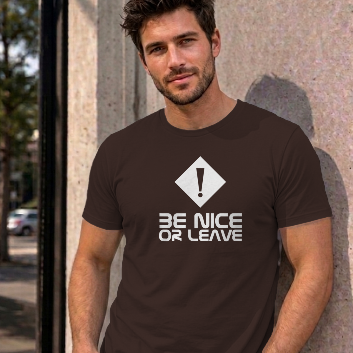 Man wearing the dark chocolate Be Nice or Leave graphic tee