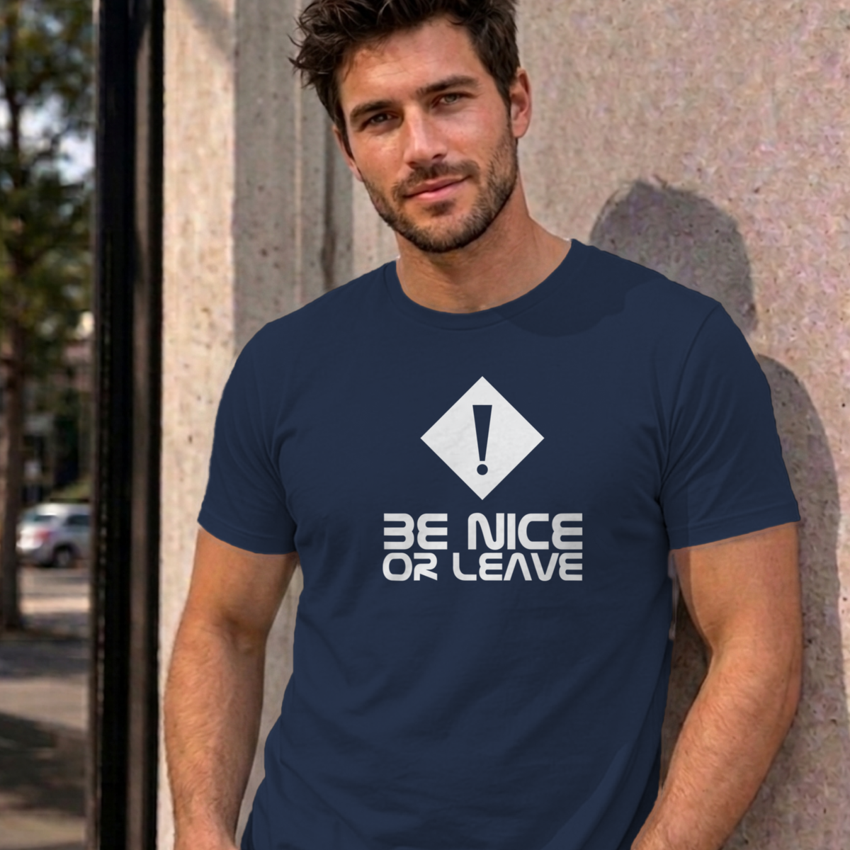 Man wearing the navy Be Nice or Leave graphic tee