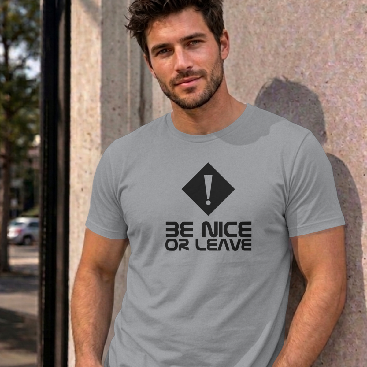 Man wearing the sport grey Be Nice or Leave graphic tee