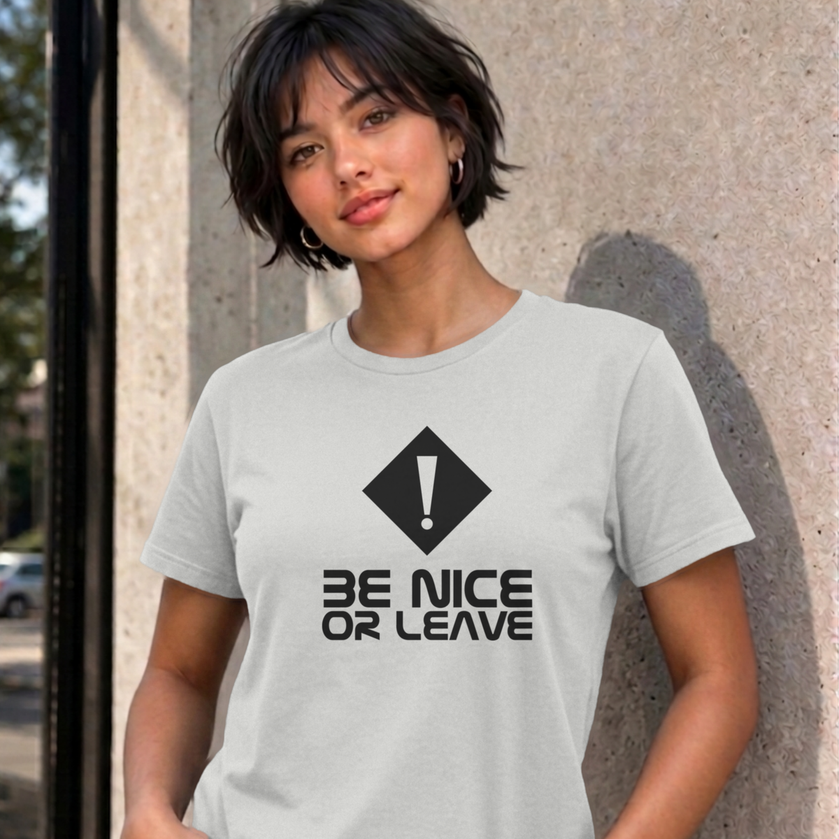 Woman wearing the ash Be Nice or Leave graphic tee