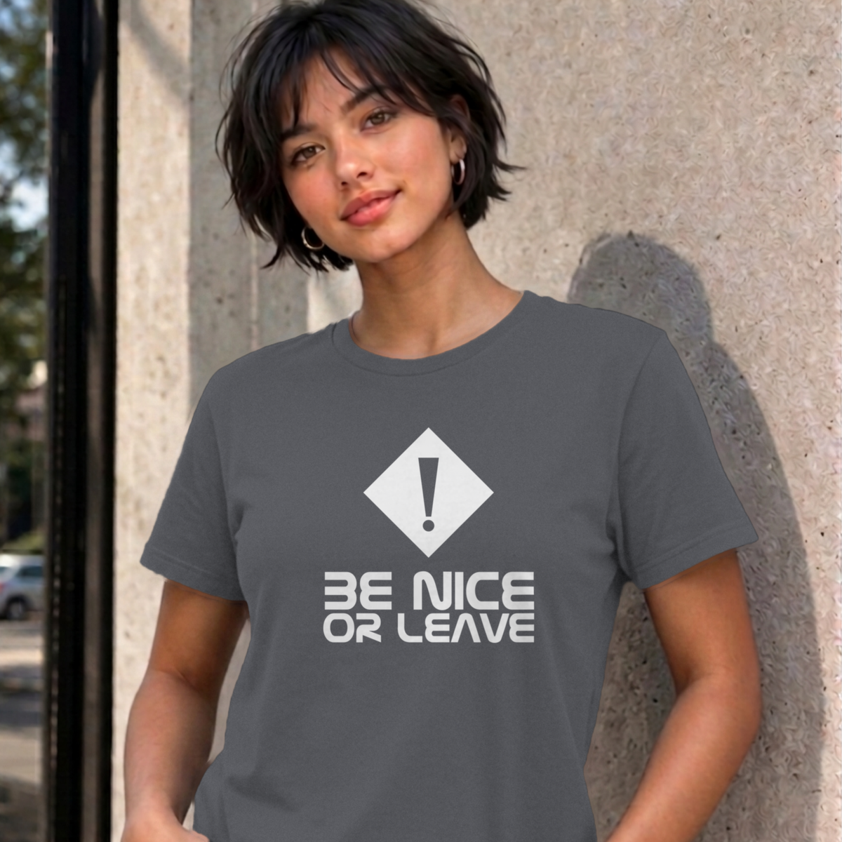 Woman wearing the charcoal Be Nice or Leave graphic tee