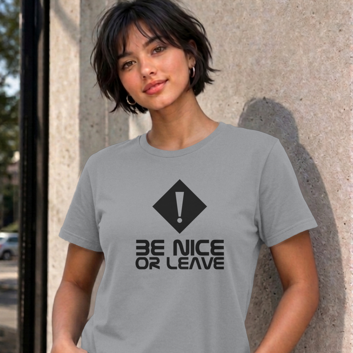 Woman wearing the sport grey Be Nice or Leave graphic tee