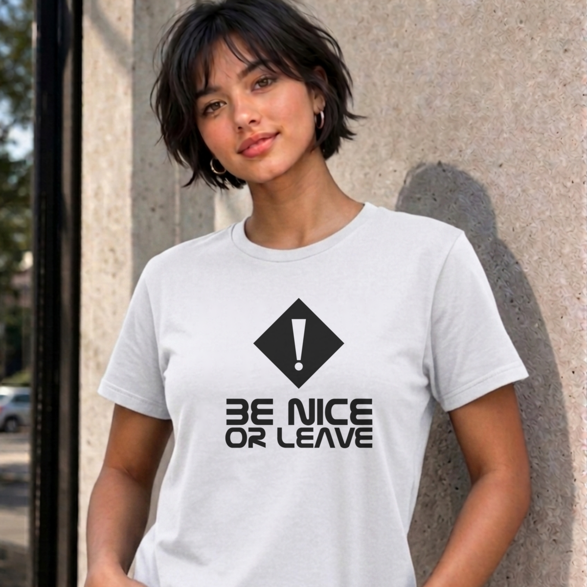 Woman wearing the white Be Nice or Leave graphic tee