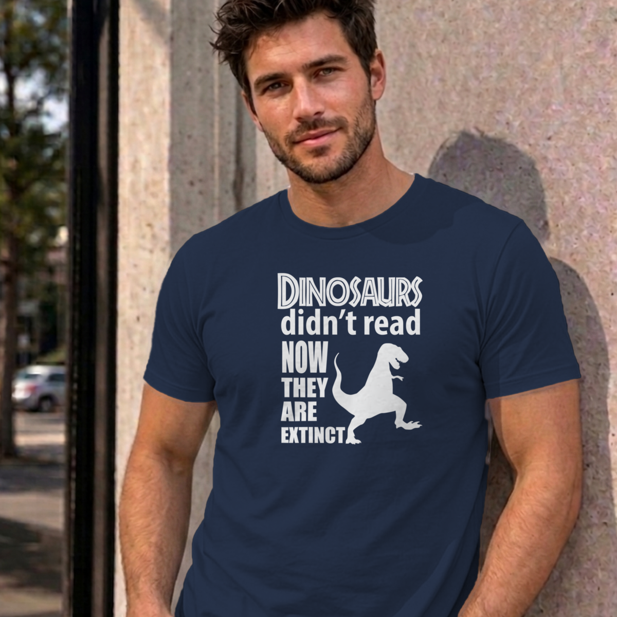 Man wearing the navy Dinosaurs Didn't Read graphic tee