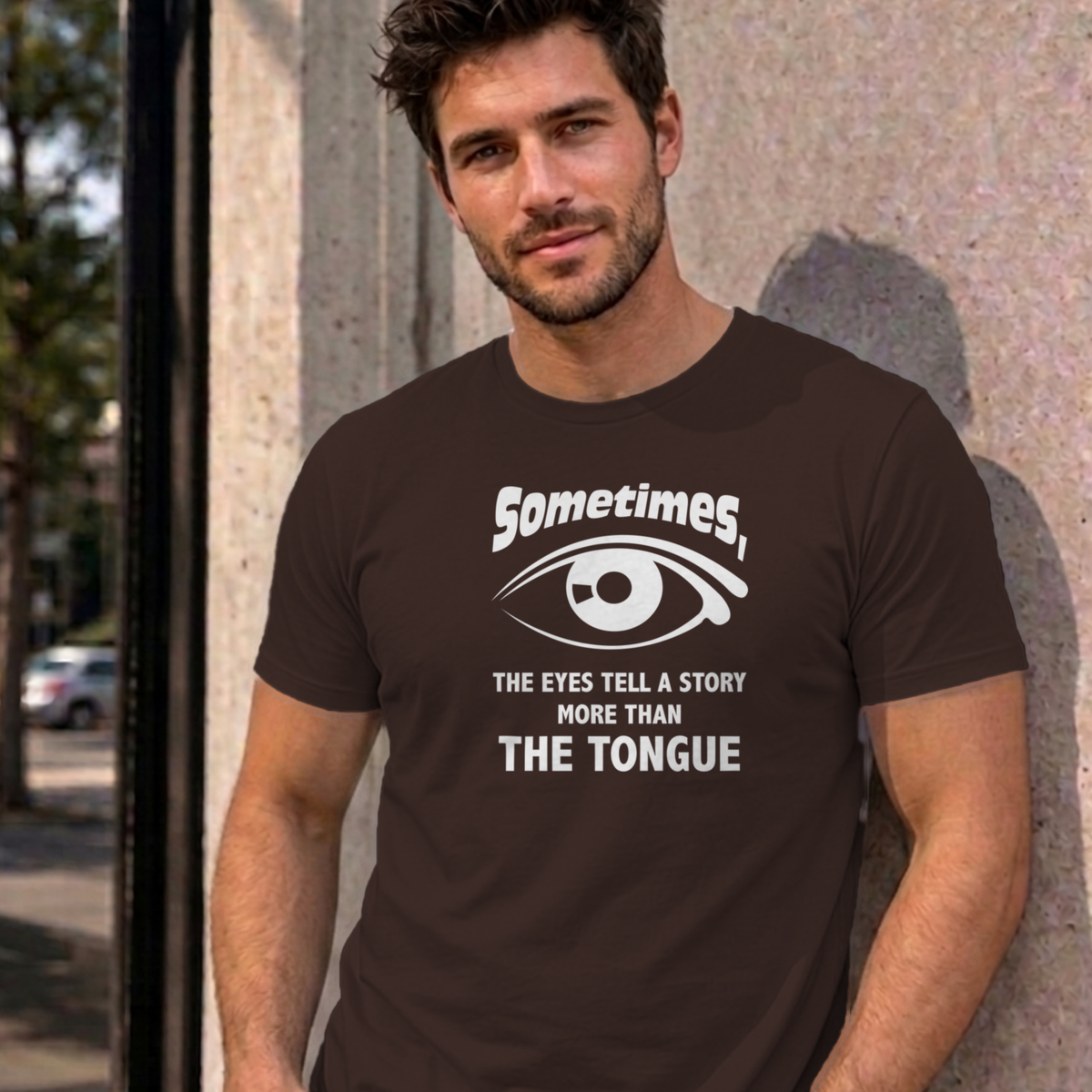 Man wearing the dark chocolate Eyes Tell a Story graphic tee