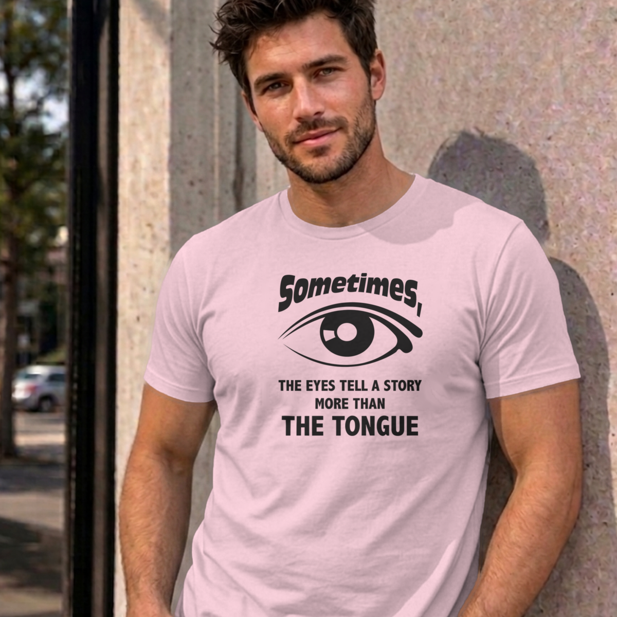 Man wearing the light pink Eyes Tell a Story graphic tee