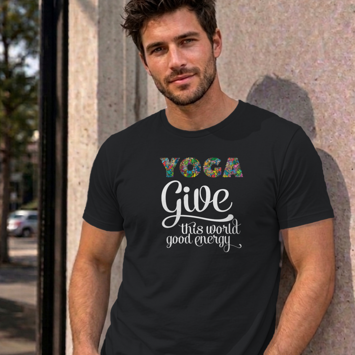Man wearing the black Give This World Good Energy graphic tee