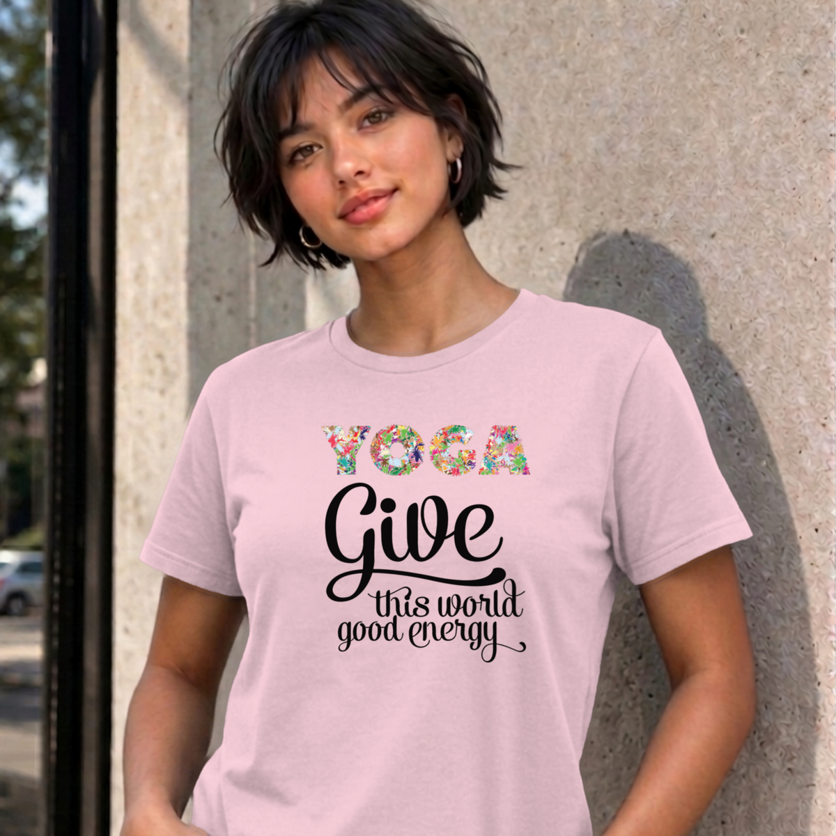 Woman wearing the light pink Give This World Good Energy graphic tee