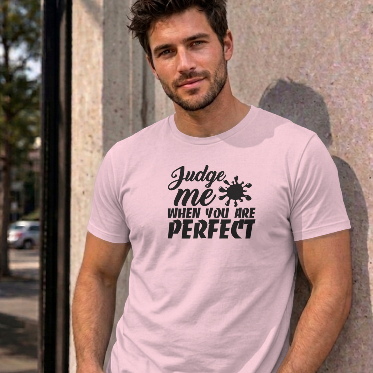 Man wearing the light pink Judge Me When You Are Perfect graphic tee