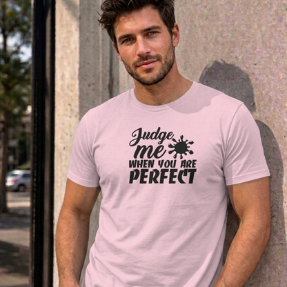 Man wearing the light pink Judge Me When You Are Perfect graphic tee