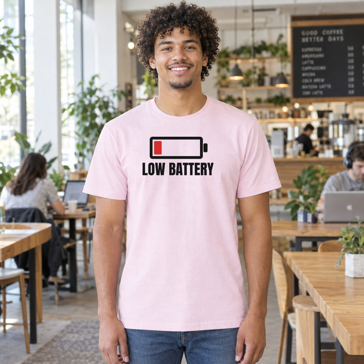 Man wearing the light pink Low Battery graphic tee