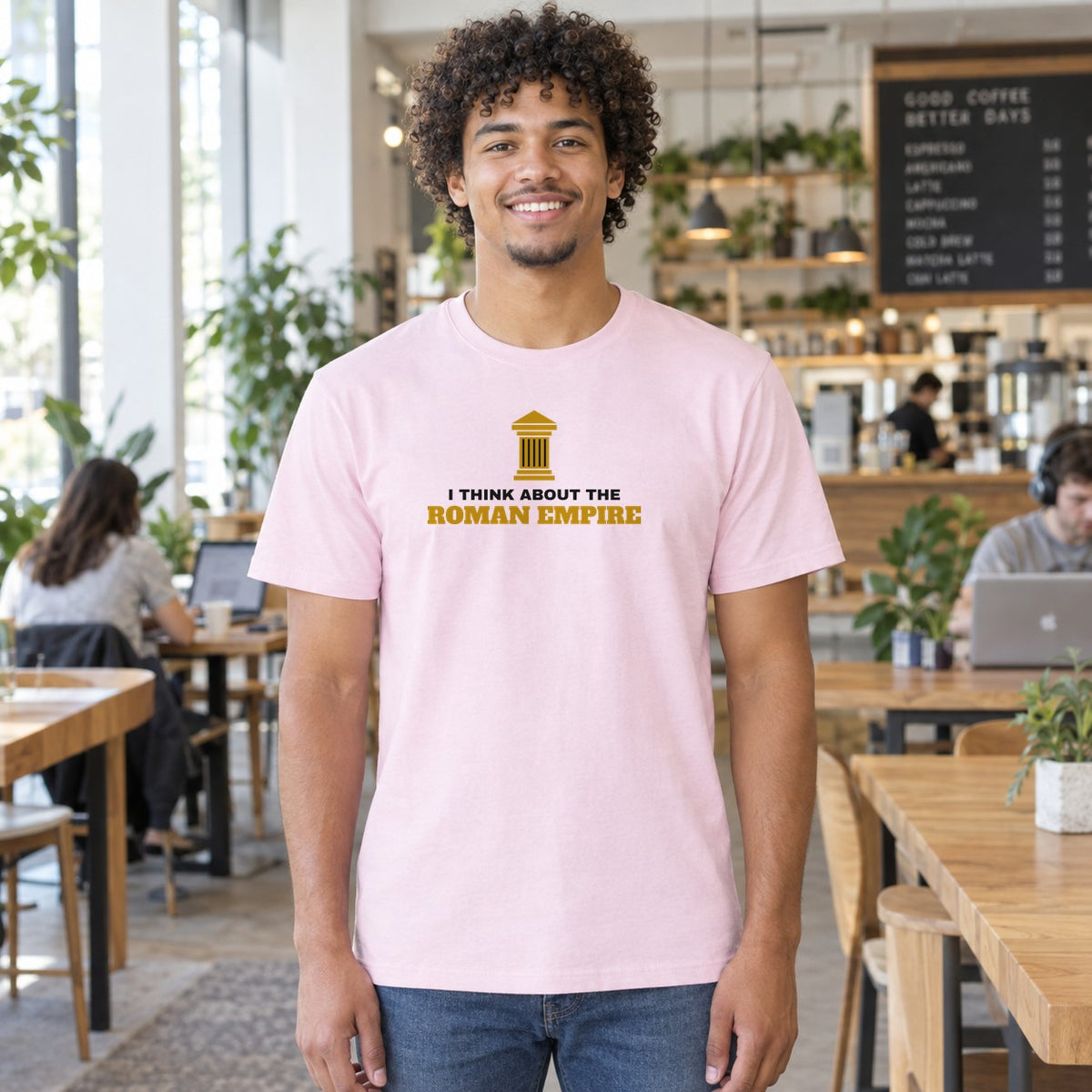 Man wearing the light pink Roman Empire graphic tee