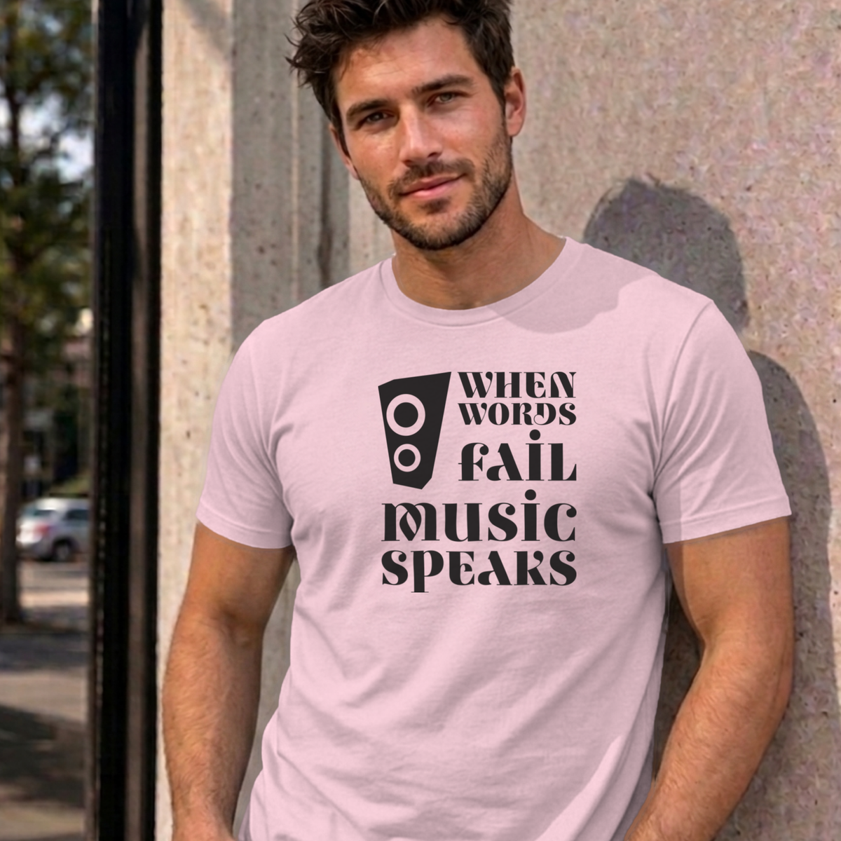 Man wearing the light pink Music Speaks graphic tee
