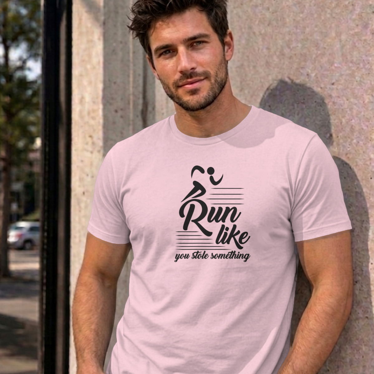 Man wearing the light pink Run Like You Stole Something graphic tee