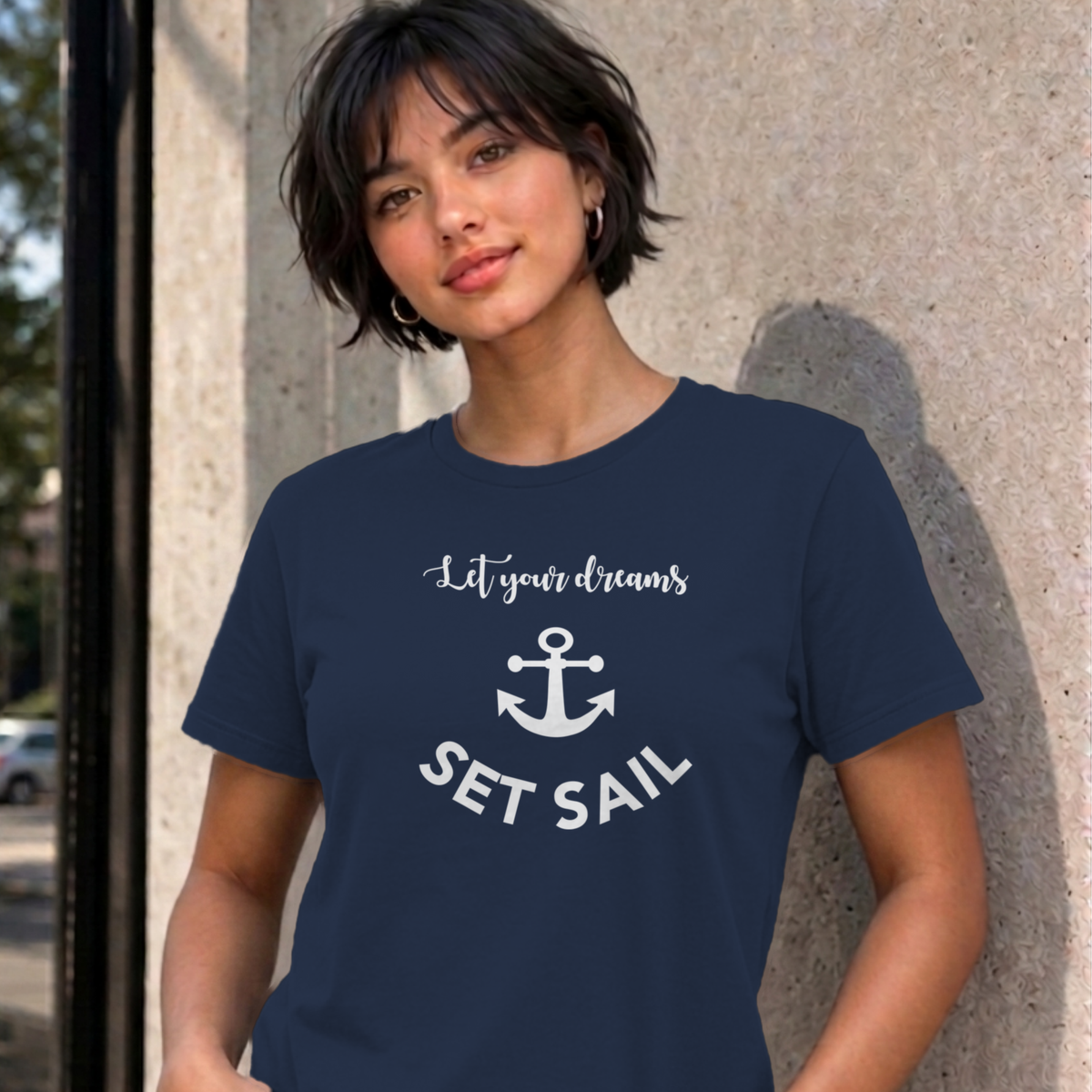 Woman wearing the navy Let Your Dreams Set Sail graphic tee