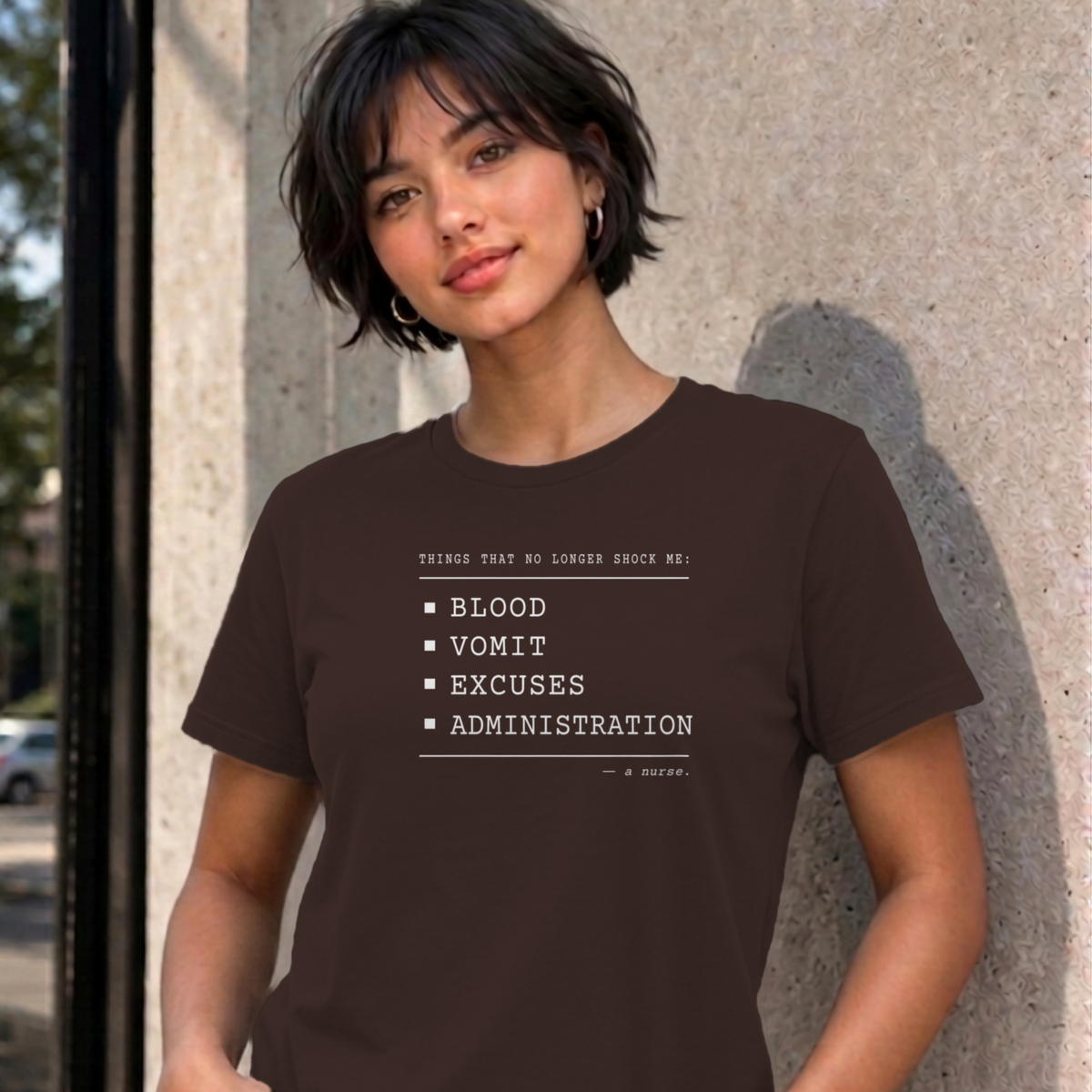 Woman wearing the dark chocolate Nurse No Longer Shocked graphic tee