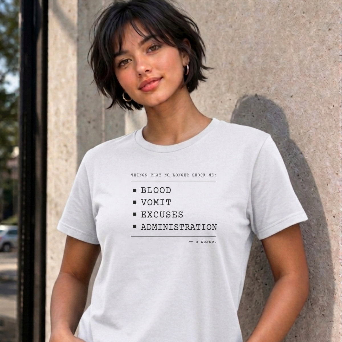 Woman wearing the white Nurse No Longer Shocked graphic tee