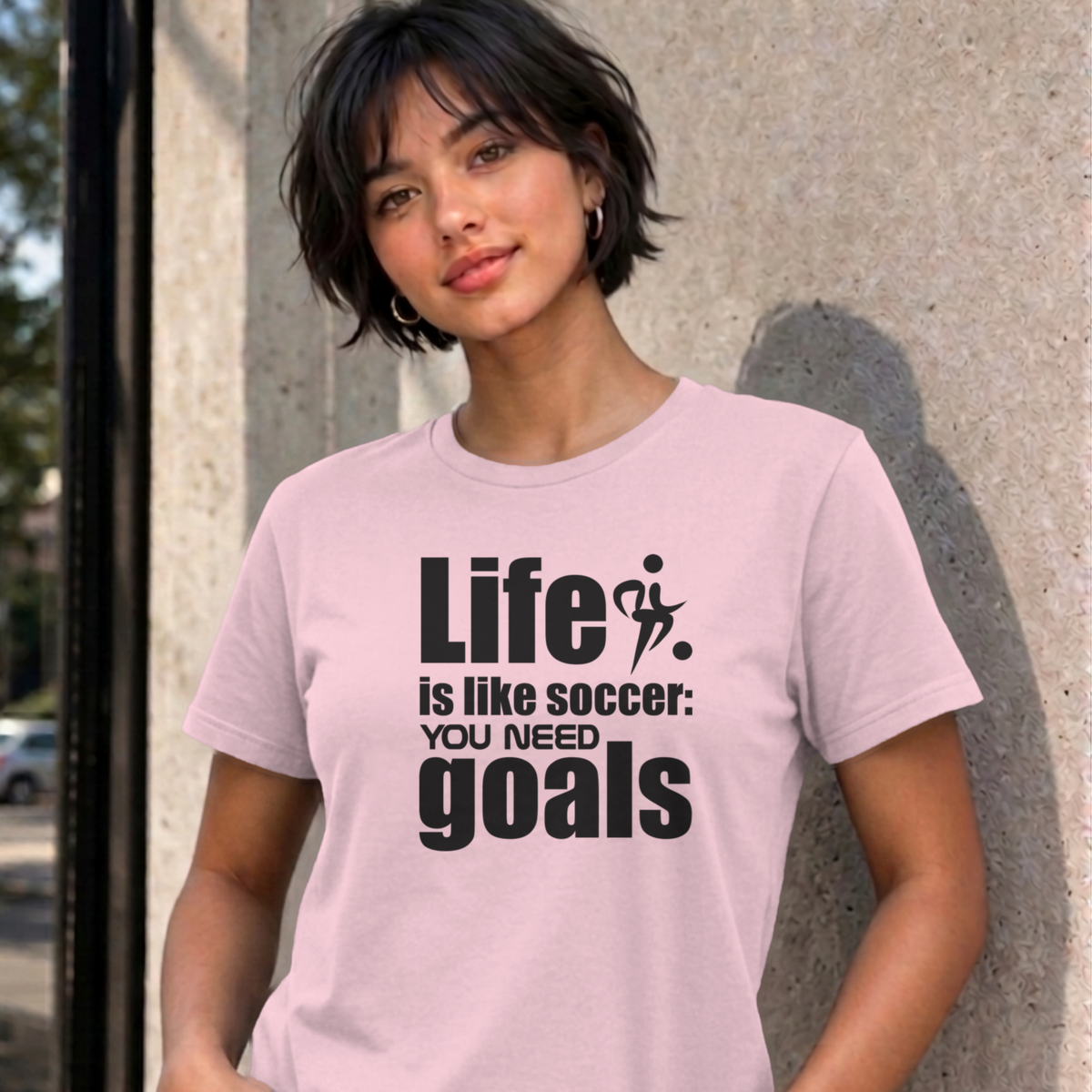 Woman wearing the light pink Life Is Like Soccer graphic tee