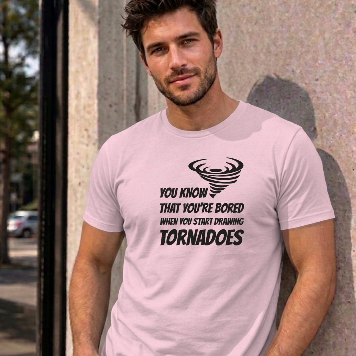 Man wearing the light pink Drawing Tornadoes graphic tee