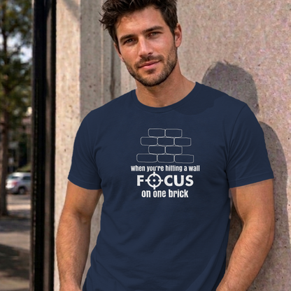 Man wearing the navy Focus on One Brick graphic tee