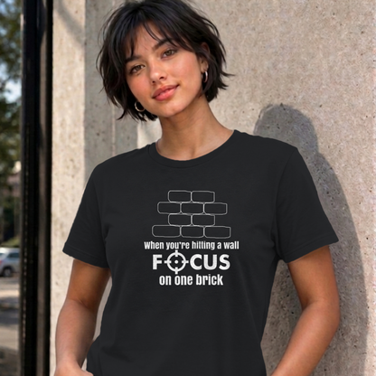 Woman wearing the black Focus on One Brick graphic tee