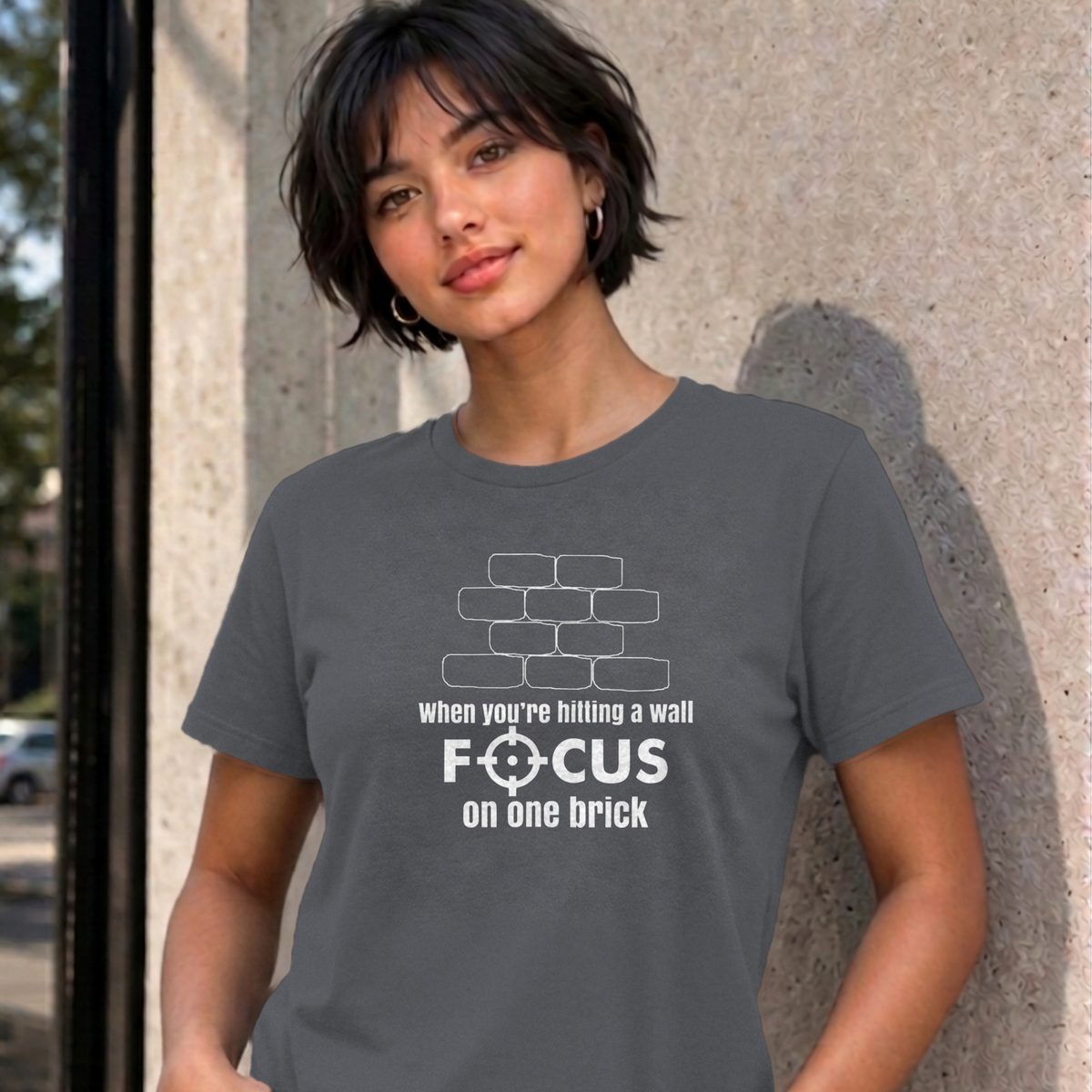 Woman wearing the charcoal Focus on One Brick graphic tee