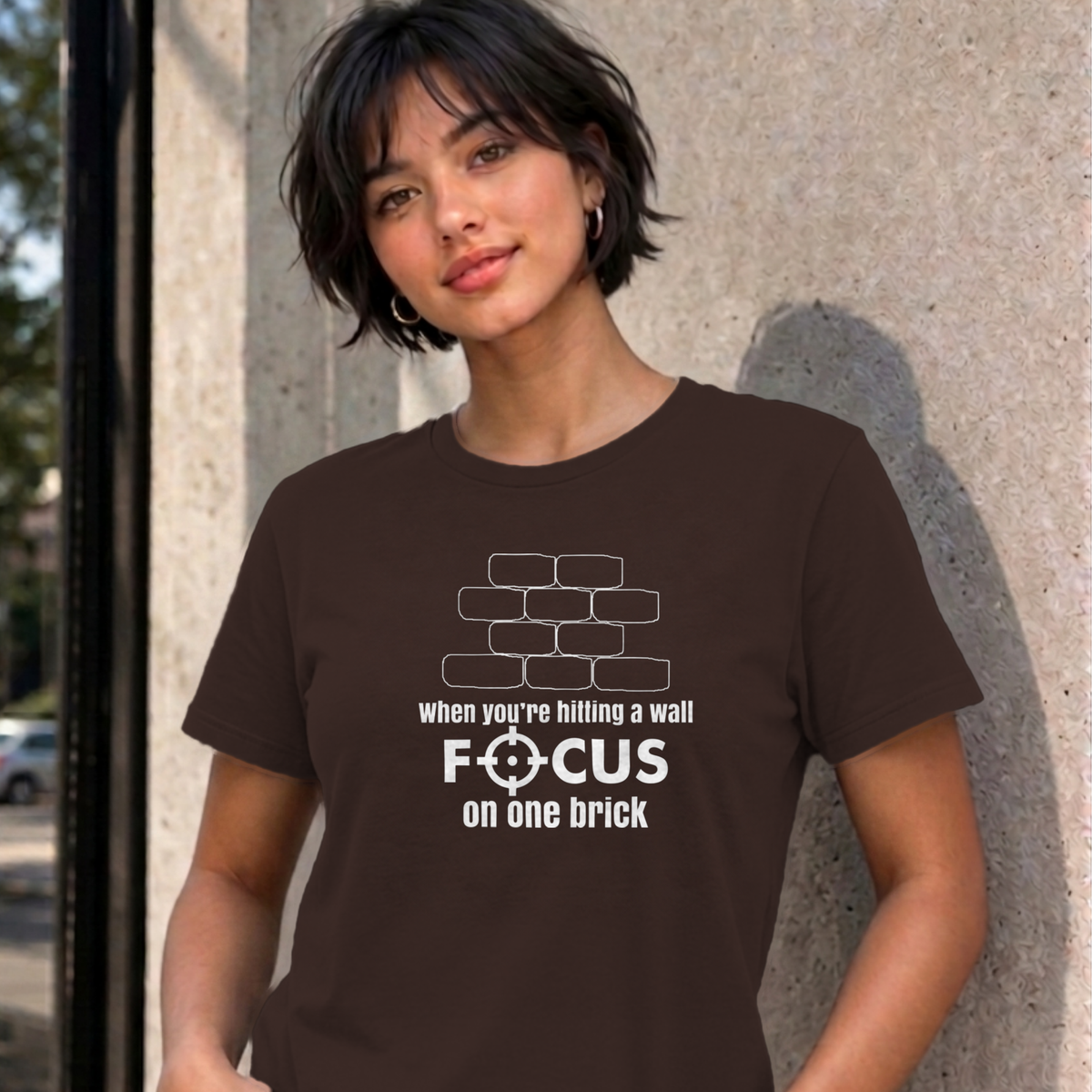 Woman wearing the dark chocolate Focus on One Brick graphic tee