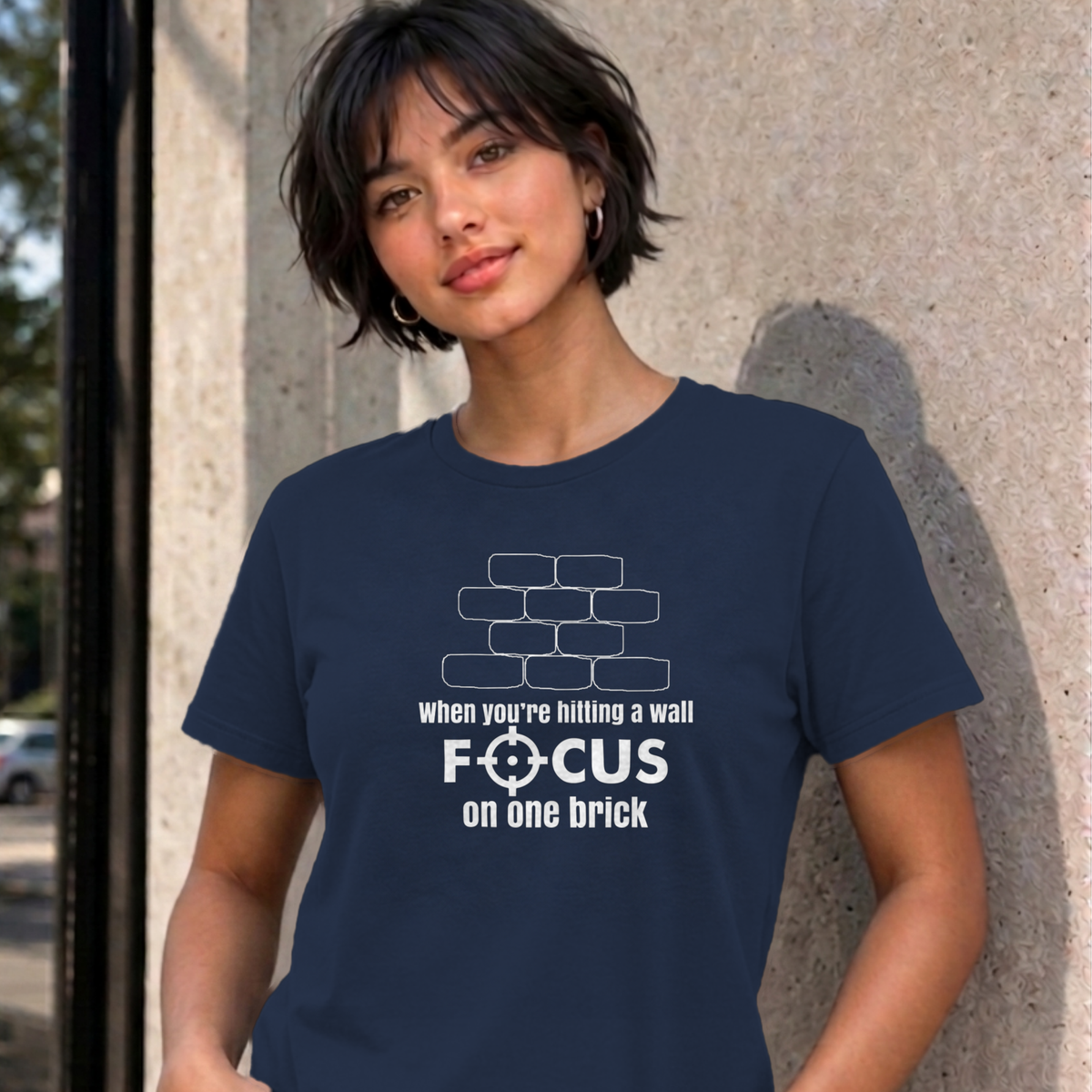 Woman wearing the navy Focus on One Brick graphic tee