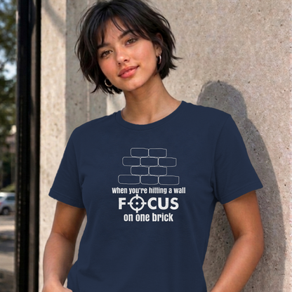 Woman wearing the navy Focus on One Brick graphic tee