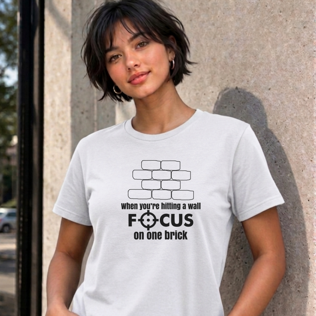Woman wearing the white Focus on One Brick graphic tee