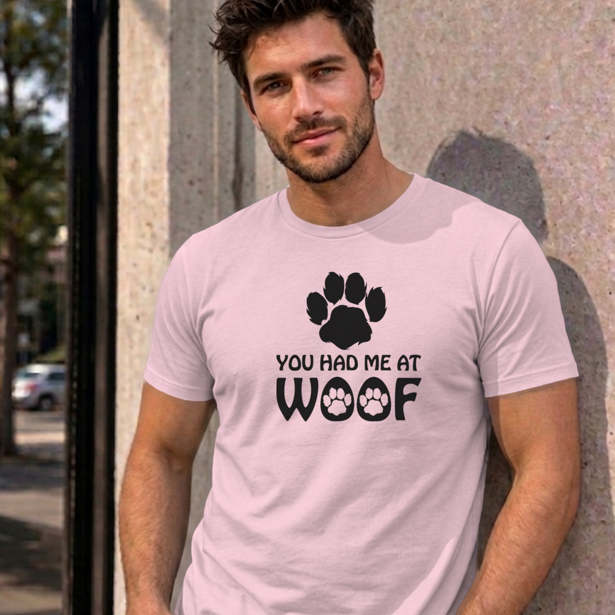 Man wearing the light pink You Had Me at Woof dog graphic tee