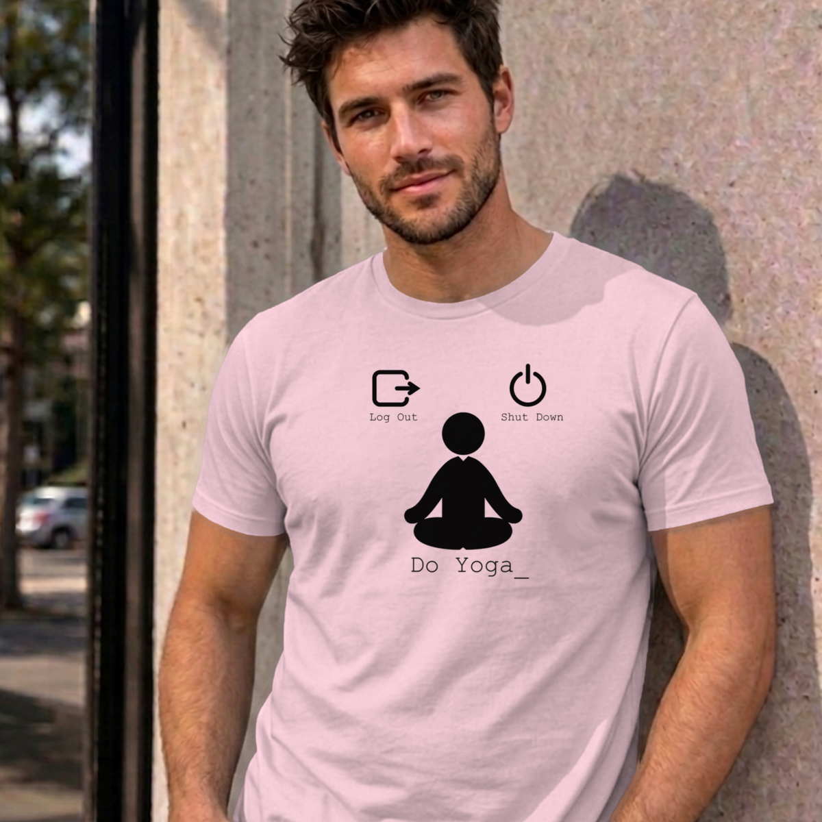 Man wearing the light pink Log Out Shut Down Do Yoga graphic tee