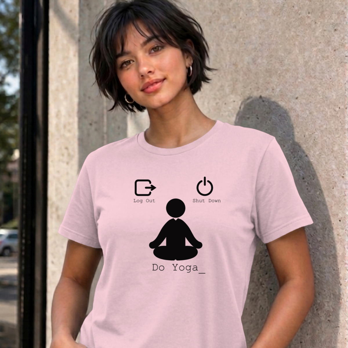 Woman wearing the light pink Log Out Shut Down Do Yoga graphic tee